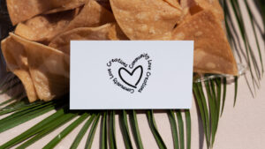 Photo of a business card with tortilla chips and a palm leaf in the background
